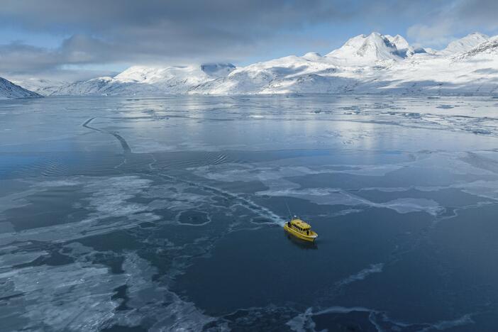A boat rides through a frozen sea inlet outside of Nuuk, Greenland on March 6.