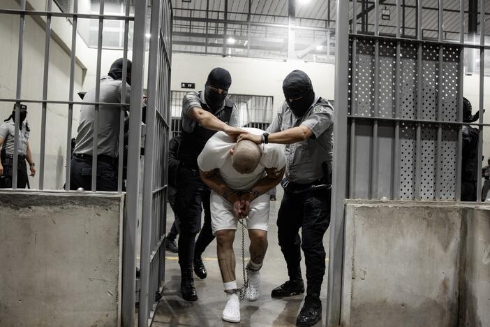 In this handout photo provided by the Salvadoran government, guards escort a newly admitted inmate inside a cell at CECOT on March 16, 2025 in Tecoluca, El Salvador.