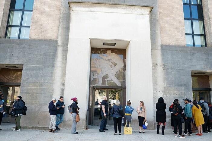 Employees of the Department of Health and Human Services stand in line to enter the Mary E. Switzer Memorial Building on April 01, 2025 in Washington, DC. Widespread layoffs began Tuesday across the agency.