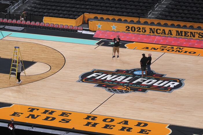 Workers make final preparations around the Men's NCAA Final Four college basketball court at the Alamodome, Monday in San Antonio. The men tip-off on Saturday. The Women's Final Four tournament, played in Atlanta, begins on Friday.