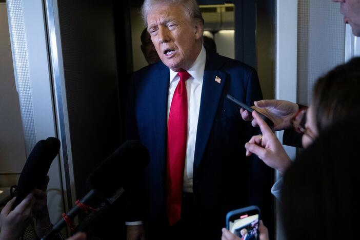 President Trump speaks to members of the press aboard Air Force One on Sunday.