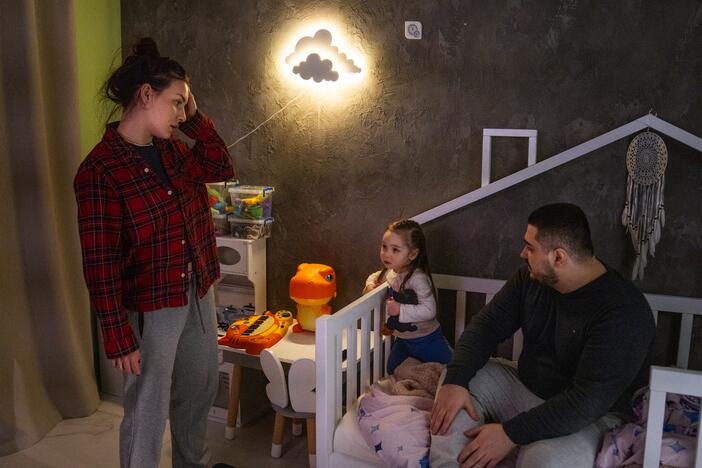 Hanna and Arkadii Rubin try to convince their daughter Leya, 2, to go to bed, although she doesn't want to. They live in an apartment in Kharkiv where, just over a year ago, part of the building was damaged in a missile attack.