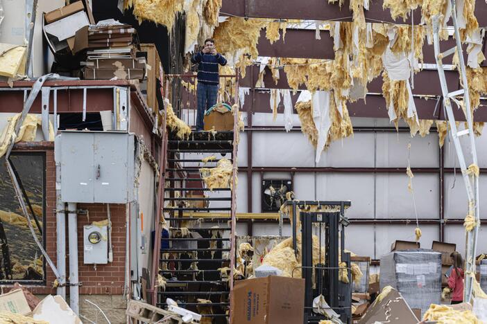 William Fraser takes photographs inside the warehouse of a damaged building of Specialty Distributors after severe weather passed through an industrial park on Thursday in Jeffersontown, Ky. (AP Photo/Jon Cherry)