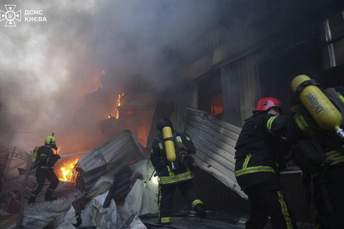In this photo provided by the Ukrainian Emergency Service, emergency services personnel work to extinguish a fire following a Russian missile attack in Kyiv, Ukraine, Sunday, April 6, 2025.