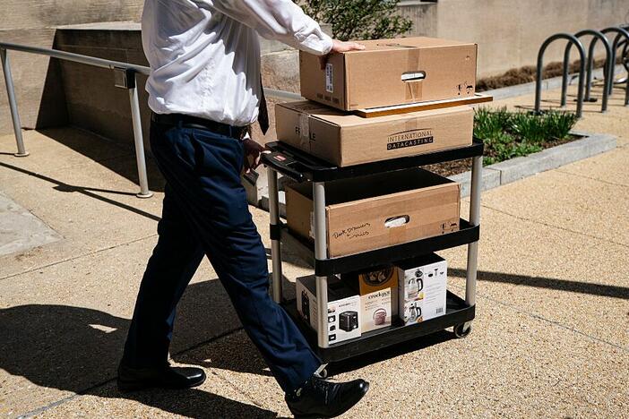 A worker wheels out the belongings of a fellow employee who was dismissed, outside of the Mary E. Switzer Federal Office Building, which houses HHS offices in Washington, D.C., on Tuesday.