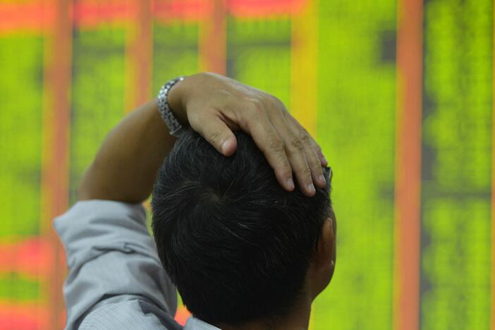 An investor monitors share prices at a securities trading office on Monday in Hangzhou, China.<br><br>