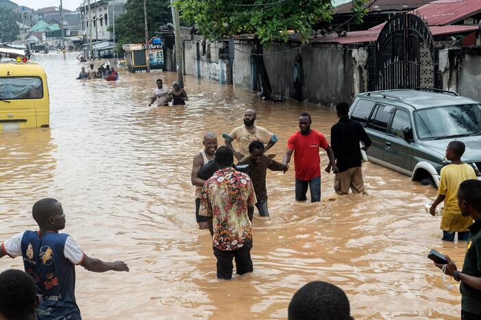 People walk through the flooded streets of Kinshasa, Democratic Republic of Congo on Sunday.