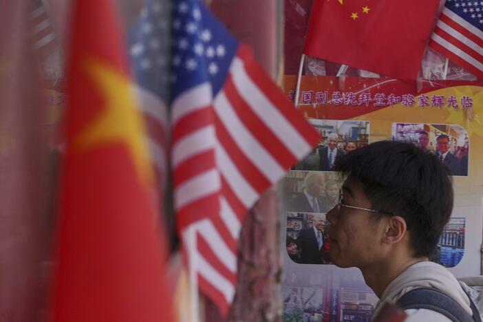 A man walks into a merchandise store displaying Chinese and United States' national flags, in Beijing on April 3.