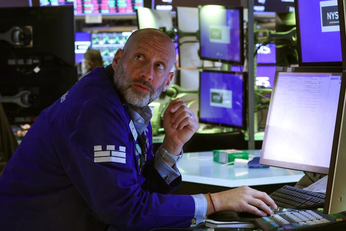 A trader works on the floor of the New York Stock Exchange (NYSE) at the opening bell on Tuesday. Stocks were modestly higher on Wednesday, although investors remained on edge after four days of heavy losses.