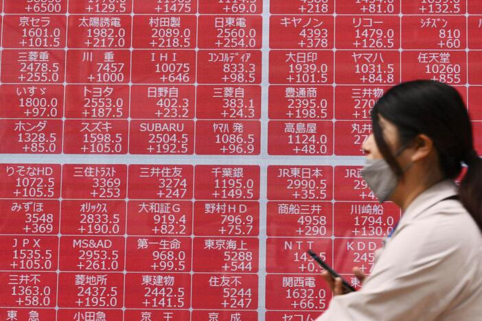A person walks past an electronic stock board at a securities firm in Tokyo on Thursday.