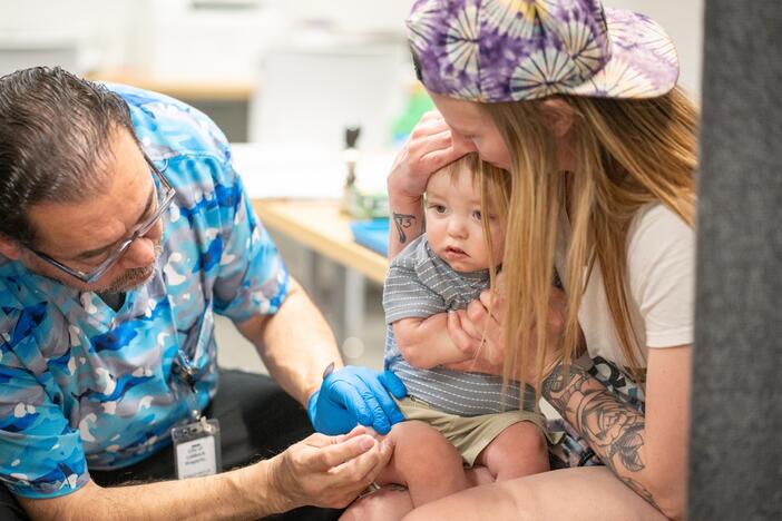 One-year-old River Jacobs is held by his mother, Caitlin Fuller, while he receives an MMR vaccine from Raynard Covarrubio, at a vaccine clinic held by the Lubbock Public Health Department on March 1 in Lubbock, Texas. A measles outbreak in West Texas has led to more than 500 cases, 57 hospitalizations and the deaths of two school-age children.