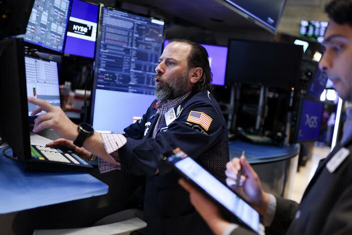 Traders work on the floor of the New York Stock Exchange at the opening bell on Thursday in New York City. Stocks resumed declines after gaining spectacularly a day earlier.