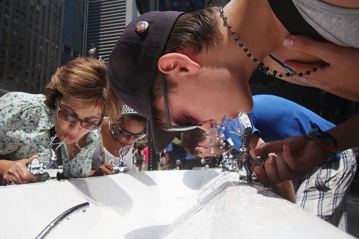 People drink water from a water fountain in New York City on July 7, 2010.