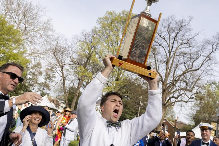 U.S. Naval Academy croquet team Imperial Wicket Liam Wert holds the trophy above his head as he celebrates his team's win over St. John's College in the 2025 Annapolis Cup. At left is Annapolis mayor, Gavin Buckley, and Superintendent of the U.S. Naval Academy, Vice Adm. Yvette M. Davids.

The 41st annual Annapolis Cup croquet tournament was held on April 5, 2025 at St. John's College between the Johnnies and the neighboring U.S. Naval Academy team. Thousands of people donned fancy dress to attend the icon…