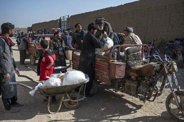 Afghan men load up food packets that were distributed as aid by the World Food Programme. Last weekend, all USAID contracts supporting humanitarian aid from WFP and other agencies in Afghanistan were canceled.