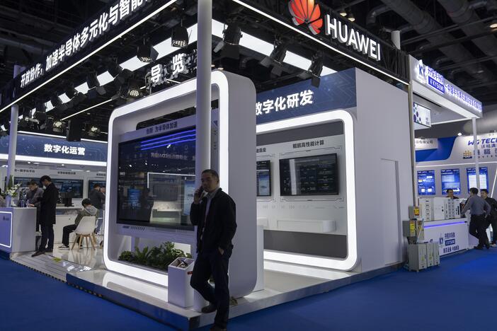 A man chats on his phone at the booth for Huawei at the 21st China International Semiconductor Expo in Beijing, in November 2024.