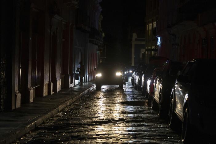 Headlights illuminate cobblestone streets in Old San Juan, Puerto Rico, during an island-wide blackout, Wednesday, April 16, 2025.