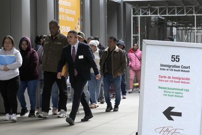 After waiting in a queue, people are led into a downtown Chicago building where an immigration court presides, Nov. 12, 2024.