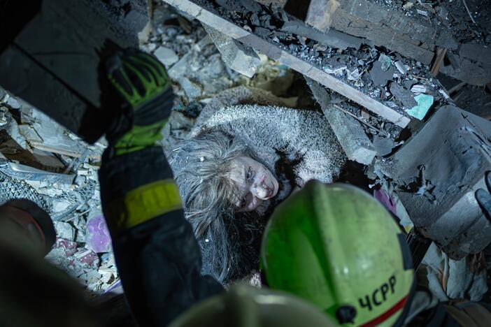 A Ukrainian woman looks at rescuers as they try to pull her out from under the rubble of a building after a Russian military strike on Kyiv, Ukraine, on Thursday. The strike occurred at 1 a.m., when most people were asleep. So far, nine people have been confirmed dead and more than 70 injured. The rescue operation is ongoing.