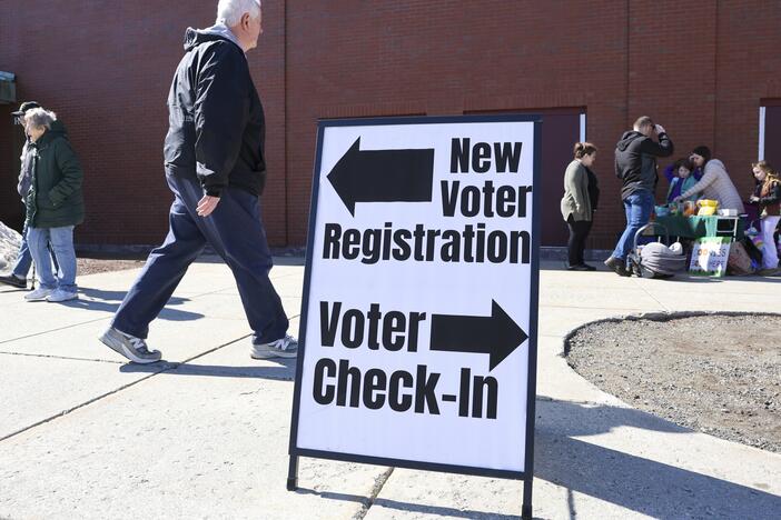 A sign for new voter registration is seen outside a polling location in Derry, N.H., on March 11.