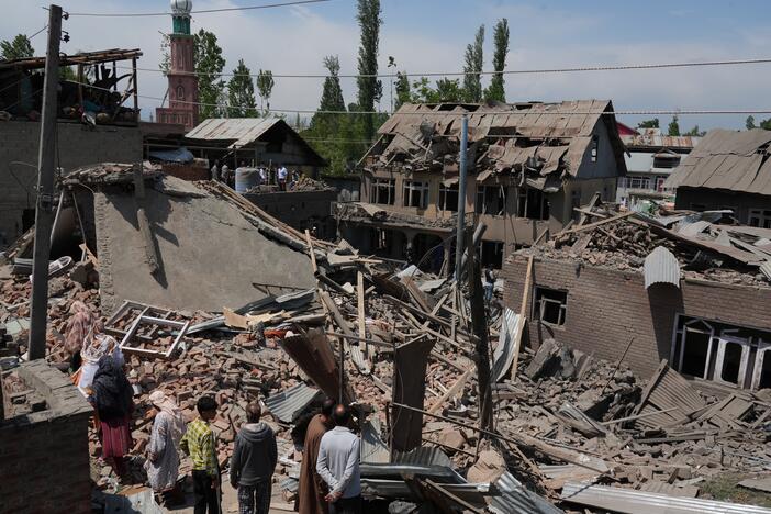 People stand near the razed house of alleged Kashmiri militant Ahsan Ul Haq Sheikh's family house in Murran area of Pulwama district on April 26, 2025.