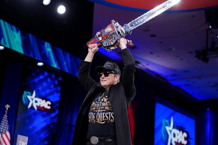 Elon Musk wields a chainsaw at the Conservative Political Action Conference on Feb. 20 in Oxon Hill, Md.