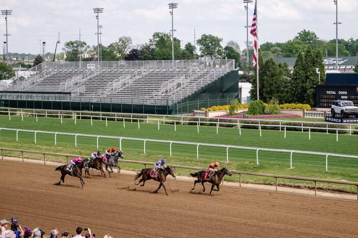 Spectators watch a horse race at Churchill Downs in Louisville, Ky., on April 30, 2025. Junior Alvarado, a jockey from Venezuela, makes his way to second place before crossing the finish line.