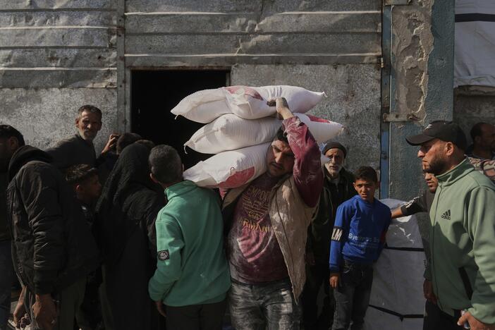 Palestinians receive bags of flour and other humanitarian aid distributed by UNRWA, the U.N. agency helping Palestinian refugees, in Jabaliya, Gaza Strip, on Tuesday.