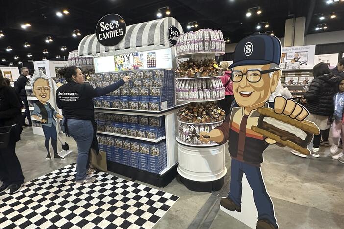 A See's Candies worker restocks the display next to a cutout of Warren Buffett at the Berkshire Hathaway shareholders meeting exhibit hall Friday, May 2, 2025 in Omaha, Neb. (AP Photo/Josh Funk)