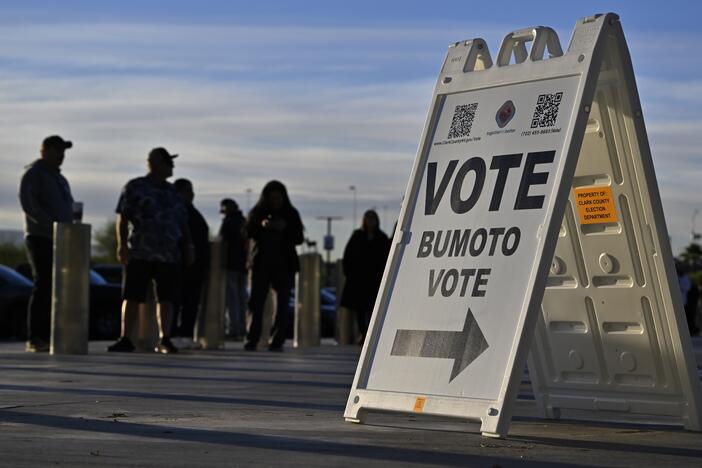Voters line up to cast their ballots at Allegiant Stadium on Nov. 5, 2024, in Las Vegas, behind a sign reading "Vote, Bumoto, Vote" — directions in English, Tagalog and Spanish.