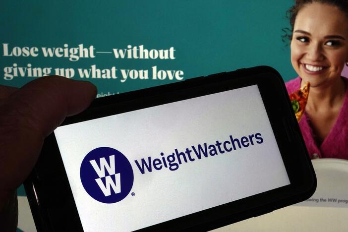 This image shows the logo of WeightWatchers on a mobile phone, and the company's website, in New York, March 7, 2023.