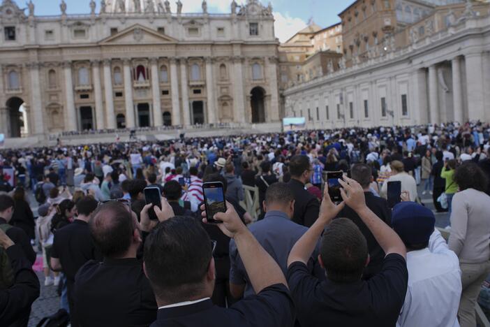 Faithful take photos the black smoke billows from the Sistine Chapel during the conclave to elect a new Pope, at the Vatican, Thursday, May 8, 2025.