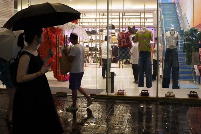 Chinese customers stroll past a clothing shop at Taikoo Li Sanlitun in Beijing.