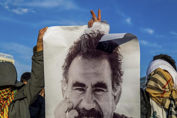 Youngsters hold a photograph of the jailed leader of the rebel Kurdistan Workers' Party, or PKK, Abdullah Ocalan as they gather to watch live on a tv screen a Pro-Kurdish Peoples' Equality and Democracy Party, or DEM, delegation members releasing an statement from Ocalan, in Diyarbakir, Turkey, Thursday, Feb. 27, 2025.