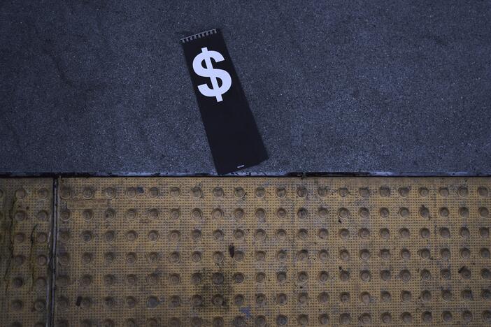 A price tag with a dollar sign lies on the sidewalk outside a Walmart store in La Habra, Calif., Wednesday, April 2.