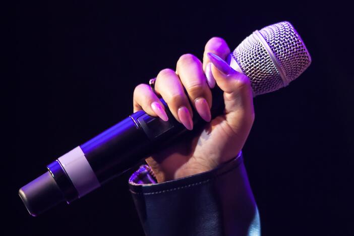 Female hand holds a wireless microphone