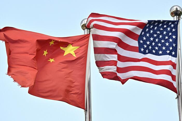 Chinese and U.S. flags wave outside a technology company in Beijing, on April 17.
