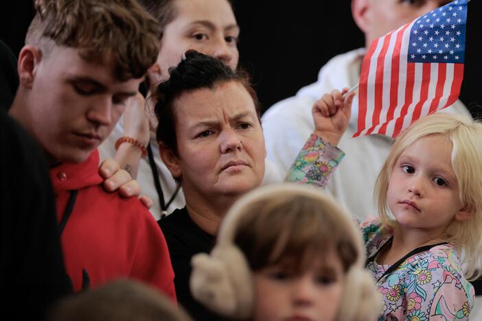 Newly arrived South Africans listen to representatives from Homeland Security and the State Department deliver welcome statements in a hangar at Atlantic Aviation Dulles near Washington Dulles International Airport on May 12, 2025 in Dulles, Va.