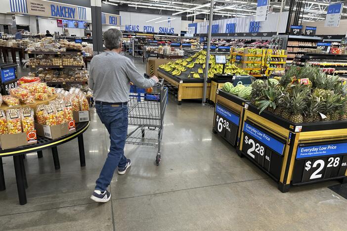 Shopper pushes a basket into the produce section of a Walmart store in Englewood, Colo.