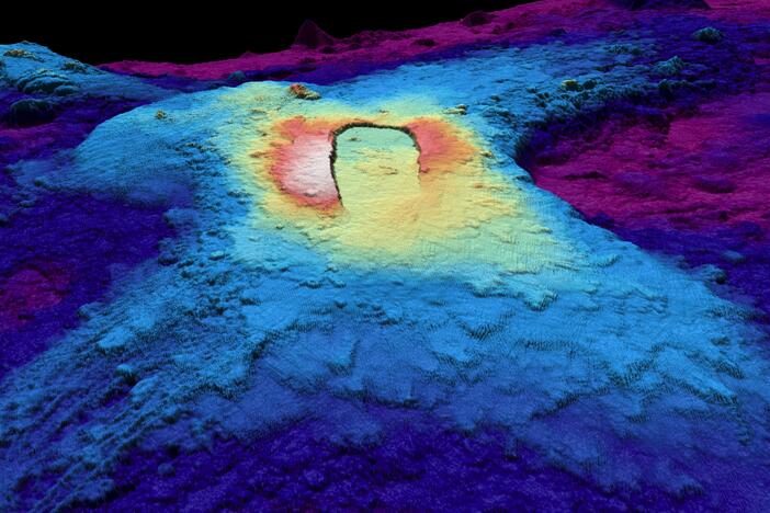 A three-dimensional map of the seabed shows the shape of the caldera of the Axial Seamount volcano. Warm colors show shallower depths and cool colors are deeper.