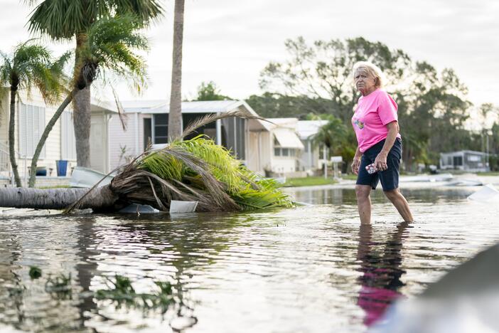 A woman walks along a flooded street in the aftermath of Hurricane Milton in Osprey, Florida. The hurricane made landfall as a Category 3 hurricane in the Siesta Key area.