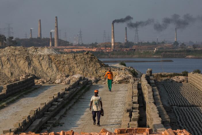 Smoke comes out from kilns at a brickfield on the outskirt of Dhaka, Bangladesh on February 6, 2021.