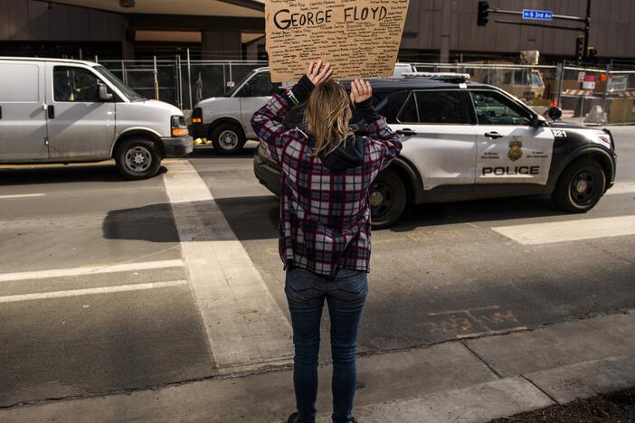 A Minneapolis Police cruiser drives by as people demonstrate outside the Hennepin County Government Center on March 9, 2021 in Minneapolis.