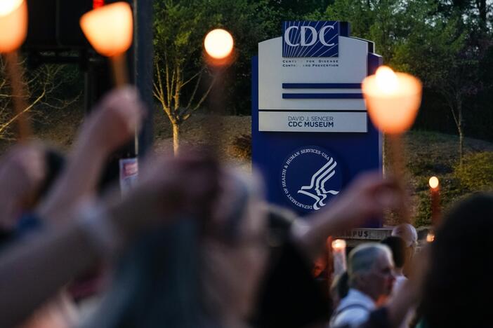 People participate in a candlelight vigil in front of the main offices of the Centers for Disease Control in Atlanta on March 28, days before thousands of CDC employees were laid off.