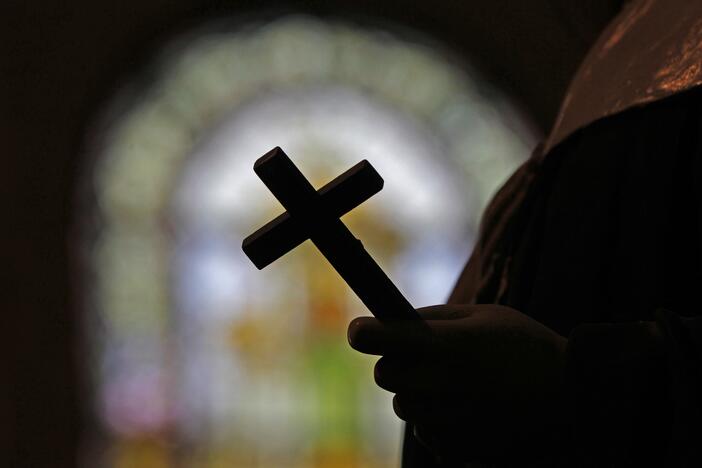 FILE - A silhouette of a crucifix and a stained glass window is seen inside a Catholic Church in New Orleans, Dec. 1, 2012.
