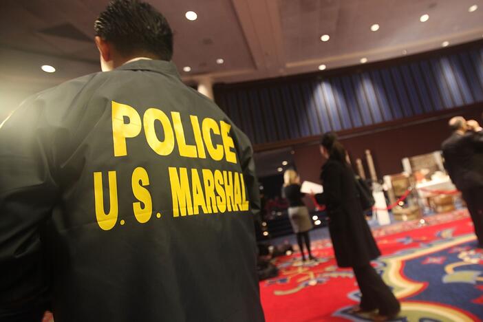 A U.S. Marshal looks on an auction in 2009 in New York City.