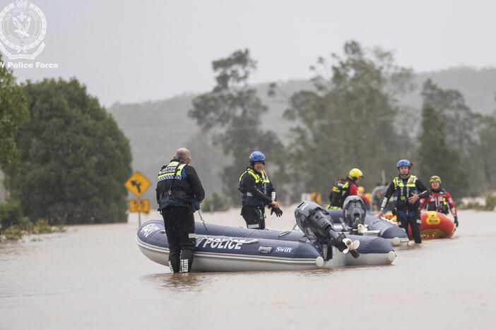 In this photo provided by the New South Wales Police, emergency workers wade through floodwaters as they prepare inflatable boats to effect rescues near Taree, Australia, Thursday, May 22, 2025.