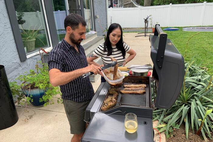 Stoio Kachev and Doanh Nghiem cook dinner on their electric grill. The couple says convenience is the main reason they switched from a propane grill — no need to refill tanks. Switching to electric also reduces their contribution to climate change.