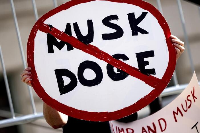 A demonstrator holds a sign during a February rally in Los Angeles to protest President Trump's billionaire adviser Elon Musk and his DOGE team.