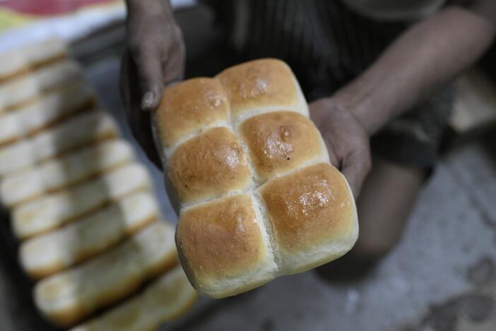 A baker holds up a loaf of pav freshly baked at the Yazdani Bakery in Mumbai. A government plan to ban wood-fired ovens in bakeries as a way to curb pollution could lead to a price increase in the beloved pav — and erase its smoky flavor.